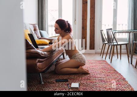 Young Woman sitting on floor and using laptop Stock Photo
