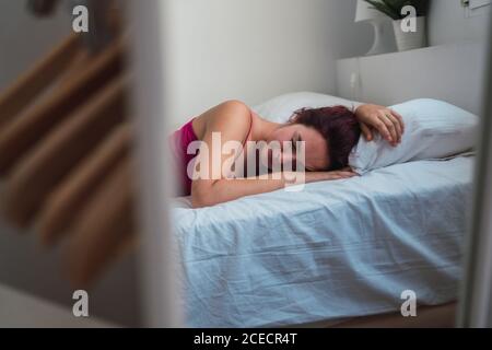 Young Woman lying on bed Stock Photo