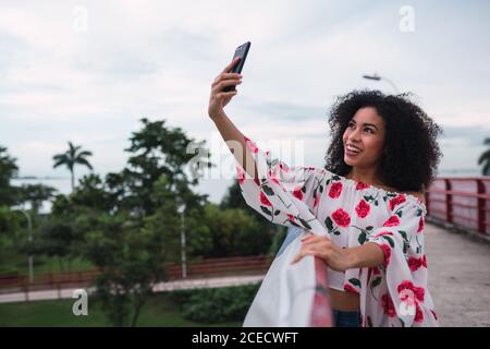 Cheerful traveling Woman taking selfie on cityscape Stock Photo
