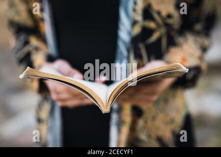 Closeup of paper notepad in hands of crop Woman in daylight Stock Photo