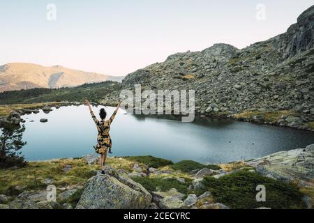Woman on rocks of small lake in mountains Stock Photo - Alamy