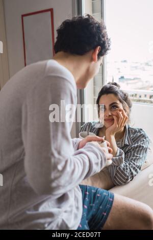 Couple with cups in living room Stock Photo