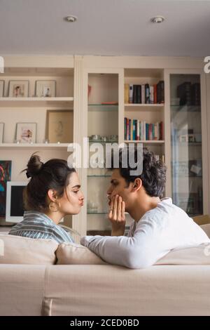 Cheerful young couple sitting on couch Stock Photo
