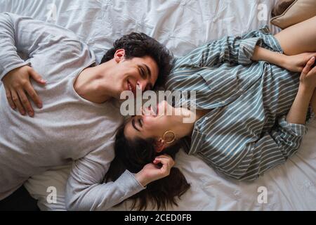 Cheerful man and Woman lying on bed Stock Photo