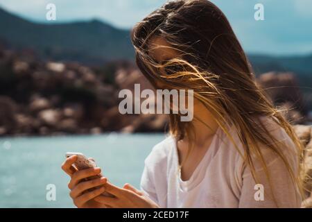 Woman taking selfie with smartphone at seaside Stock Photo