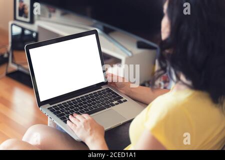 Mockup image of business woman using and typing on laptop with blank white screen in home Stock Photo