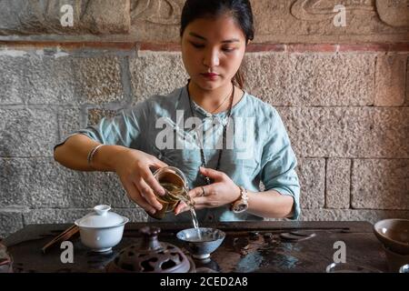 Young Asian Woman pouring water from pot while making tea on traditional ceremony Stock Photo