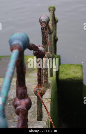 Selective focus shot of a metal railing on the river Stock Photo