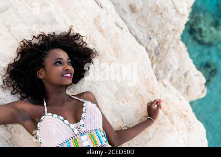 Woman lying on cliff above water Stock Photo
