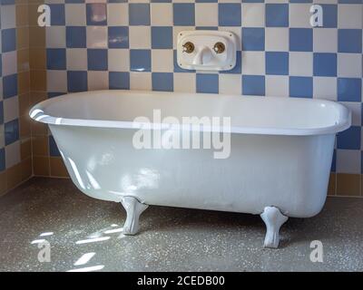 Vintage bathtub in the vintage bathroom with blue and white tile walls Stock Photo