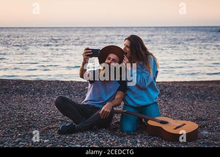 Couple with guitar on beach Stock Photo