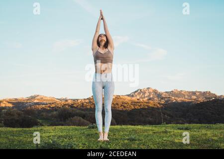Woman meditating on field Stock Photo