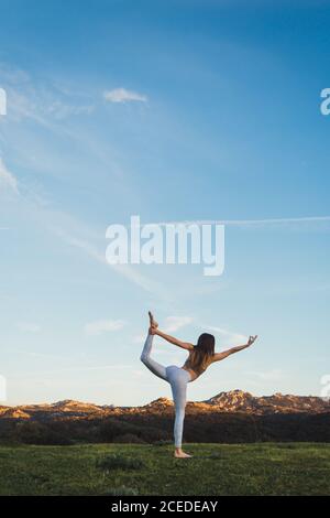 Woman stretching on field Stock Photo