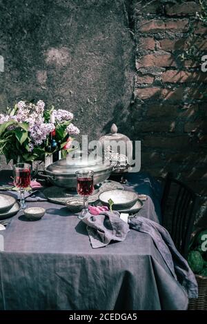 Tablecloth setting with artichokes, flowers and red wine Stock Photo