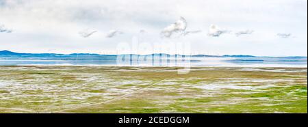 Low clouds and wind turbines reflect in the recently refilled Lake George near Canberra, ACT, Australia. The lake has been dry for many years. Stock Photo