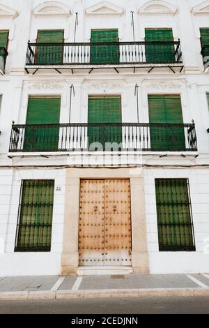 Pavement near amazing white building with closed door and shuttered windows on street of Malaga, Spain Stock Photo