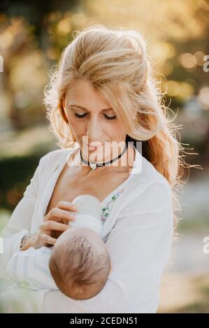 Woman feeding a baby with a bottle Stock Photo