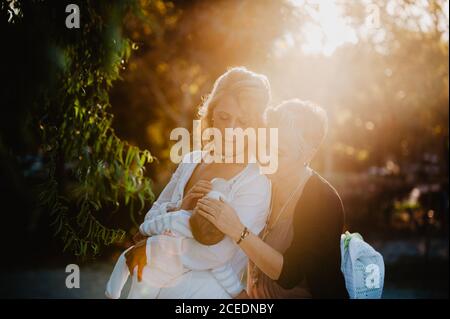 Two mature women feeding a baby with a bottle Stock Photo