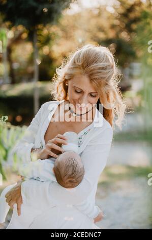 Woman feeding a baby with a bottle Stock Photo