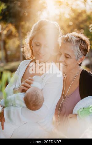 Two mature women feeding a baby with a bottle Stock Photo