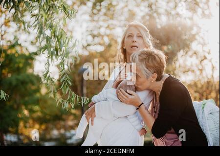 Two mature women with a baby in the park Stock Photo