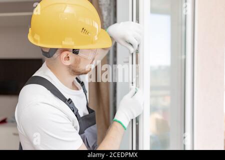 Worker in installing rubber seals on plastic upvc window Stock Photo