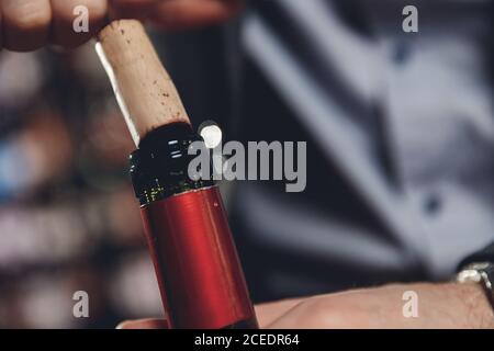 Opening wine bottle with corks crew on dark background restaurant Stock Photo