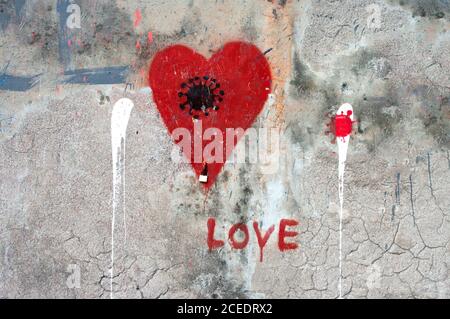 PORTOROSE, SLOVENIA - AUGUST 29, 2020: Red heart and coronavirus sign picture drawn on urban wall. Portorose, Slovenia. Stock Photo