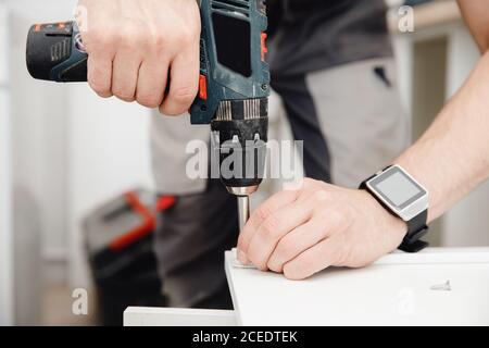 Installation and adjusting fixing kitchen cabinet door hinge adjustment Stock Photo