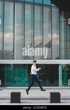 man jumping on pavement of highrise Stock Photo