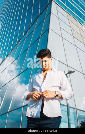 Handsome man in white shirt against skyscraper Stock Photo