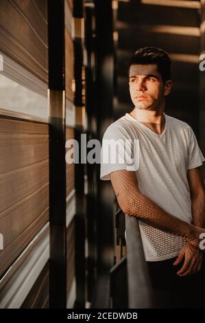 Young thoughtful man standing inside building Stock Photo