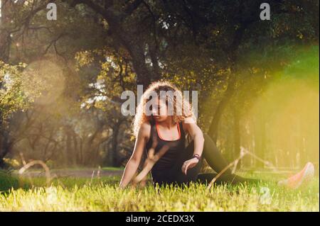 Happy Woman stretching on sunny meadow Stock Photo