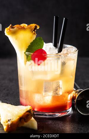 Cold mai tai cocktail in glass on black stone Stock Photo