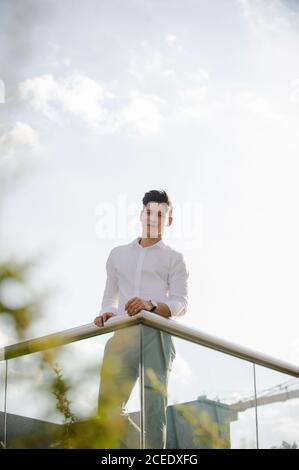 Young man leaning on railing Stock Photo