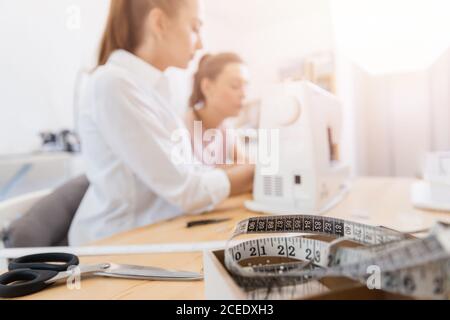 Training sew concept. Close-up sewing machine, hands of tailor and seamstress work Stock Photo
