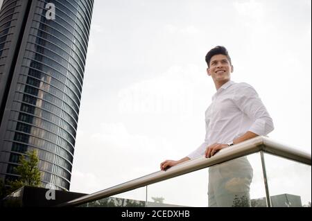 Young man leaning on railing Stock Photo