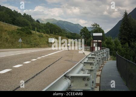 Bicyclist on highway with mountains Stock Photo