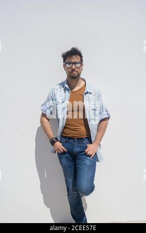 35-year-old man leaning against a wall of a typical Mediterranean house in Spain Stock Photo