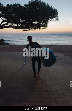 man practicing paddle surfing with neoprene in a sunrise on a paradisiacal beach Stock Photo