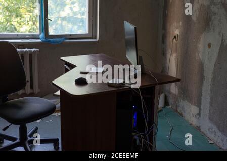 a messy desk in computer repair workshop and hands of a master, indoor ...
