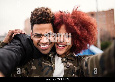 Cheerful black couple embracing and laughing Stock Photo