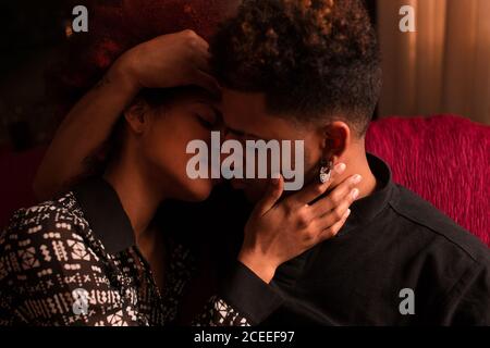 Embracing happy black couple on couch Stock Photo