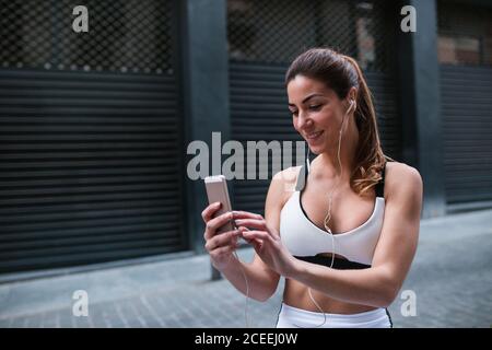 Sportive Woman using phone outside Stock Photo