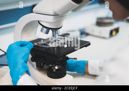 Person working with microscope in lab Stock Photo