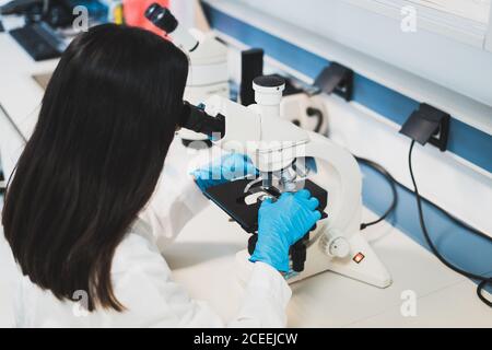 Young Woman using microscope in laboratory Stock Photo