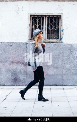 Young blonde Woman wearing hat and scarf walking by the street in Madrid, Spain Stock Photo