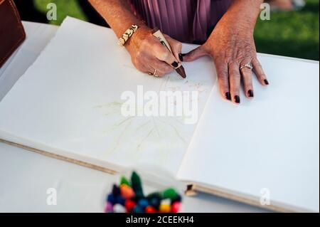 Hands of unrecognizable person writing greetings in the book. Stock Photo