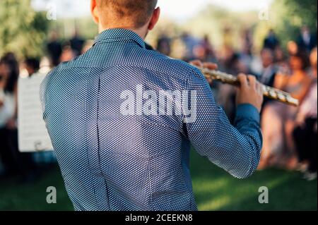 Close detail of a flute whlie flutist playing in a wedding ceremony Stock Photo