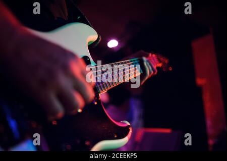 Hands of unrecognizable musician standing and playing guitar on the stage. Stock Photo
